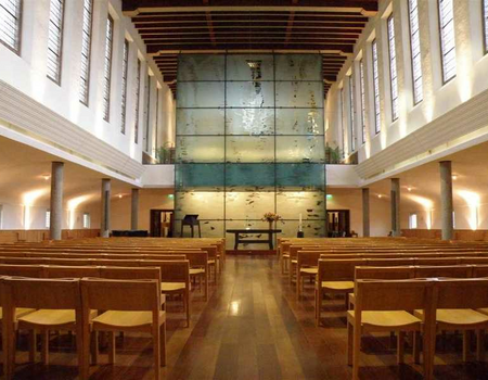 De kerkzaal na de renovatie. De glazen wand is ontworpen door de heer Jan Beutener.