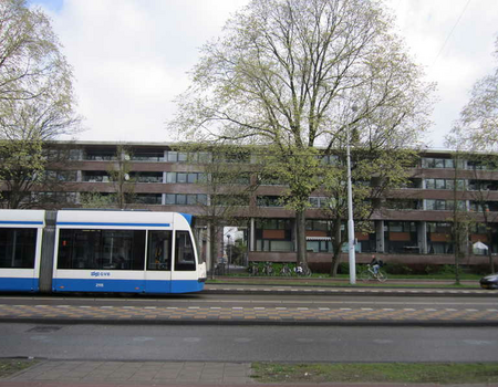 Lijn 9 op de Middenweg op weg richting centrum. Op de achtergrond enkele flats van Park De Meer, gebouwd op de plek van AJAX-stadion De Meer.