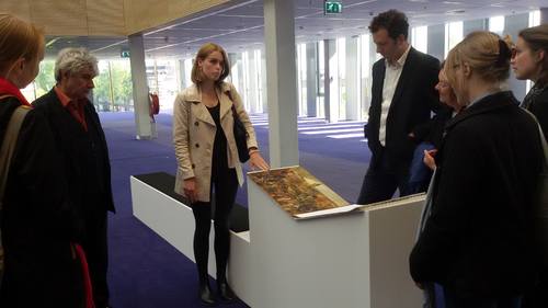 Sarah geeft uitleg aan de conservatoren over het historische bladerboek