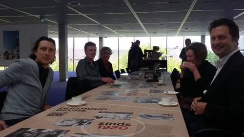 De conservatoren met koffie aan de bedrukte beurstafel