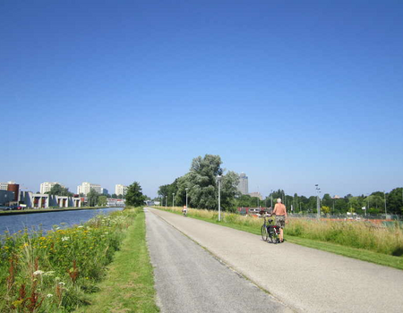 De Weesperzijde (ringdijk) tussen de Omval en de Duivendrechtsebrug. Rechts beneden in de dijk Sportpark Drieburg en het volkstuinencomplex Amstelhof.