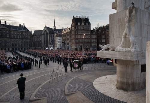 : De kranslegging bij het Nationaal Monument op de Dam door Z.M. de Koning en H.M. de Koningin tijdens de Nationale Dodenherdenking, 2014. Foto door Nationaal Comité 4 en 5 mei, Jasper Juinen