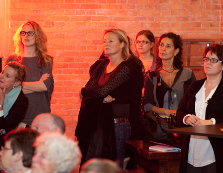 De aanwezigen achter in de zaal luisteren aandachtig naar de stand van zaken van het project.